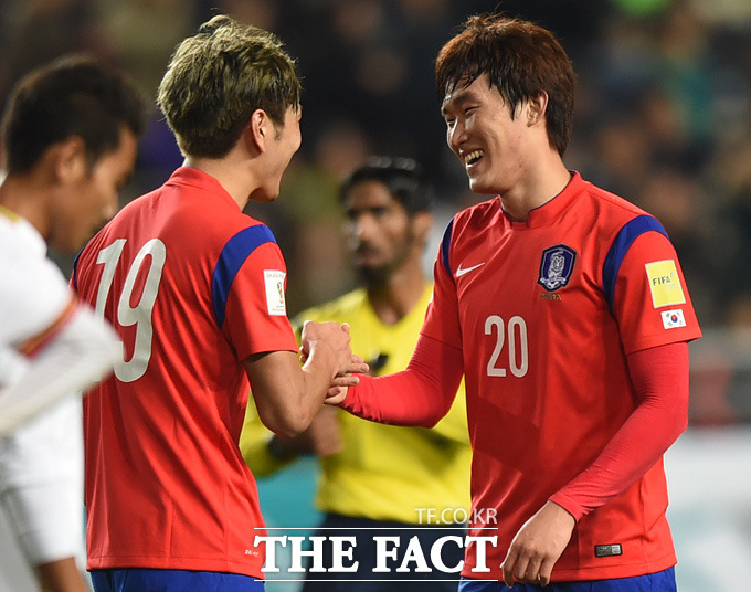 한국의 장현수가 팀의 세번째골을 성공시킨 후 김영권과 하이파이브를 나누며 환하게 웃고 있다.