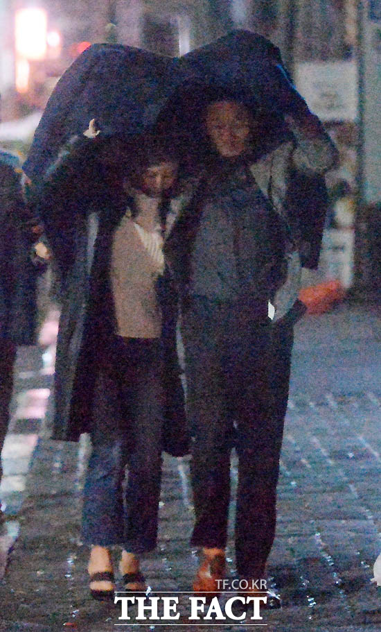 영화의 한 장면처럼~ 황정음(왼쪽)과 이영돈 커플이 갑자기 내리는 눈을 코트 아래서 피하며 자리를 이동하고 있다. /문병희 기자