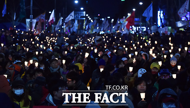 행진의 목적지인 서울대학병원에 집결한 참가자들이 촛불을 들어보이고 있다./이새롬 기자