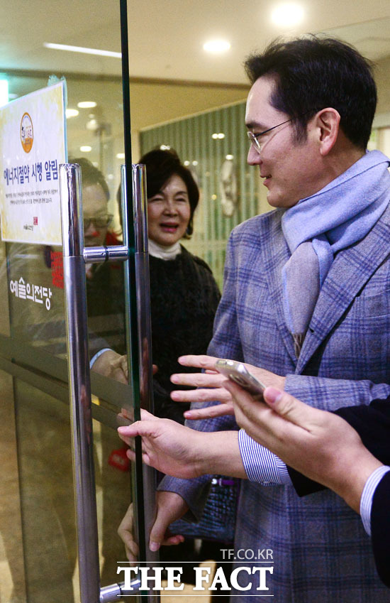 주차장으로 드러서는 순간 갑자기 문이 닫히자, 이 부회장이 어머니 홍 관장이 안전하게 나오도록 문을 열고 있다.