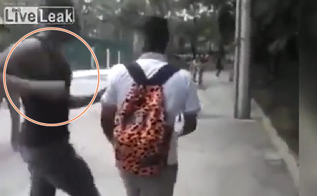 검은색 민소매 셔츠를 입은 남자가 오렌지색 가방을 멘 소년을 공격하고 있다. /유튜브 영상 캡처