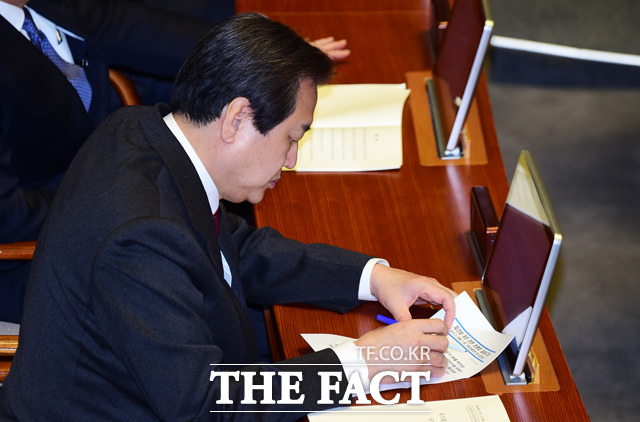 새누리당 김무성 대표가 파견법 개정 관련 토론회 자료를 정리하고 있다.