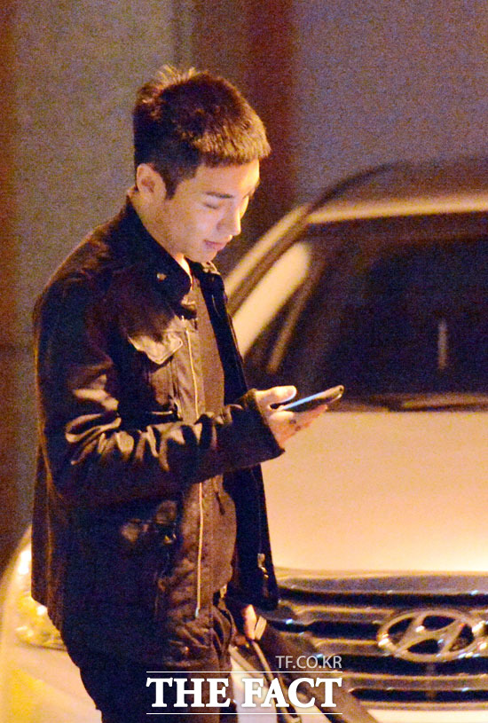 이특이 밝은 표정으로 휴대전화를 확인하고 있다.