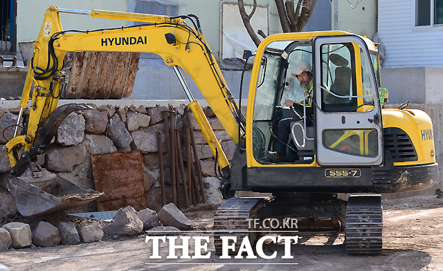 흙 묻은 작업복을 입은 강기갑 전 통합진보당 대표가 굴착기 작업에 열중하고 있다.