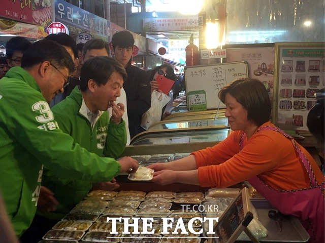 안 대표가 시장에서 상인이 주는 떡을 먹고 있다./인천=서민지 기자