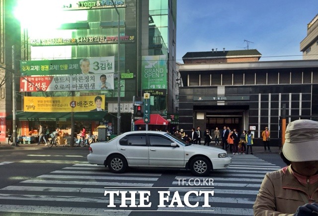 망원역 1번출구 앞 후보들의 현수막과 마포을 주민들./마포을=서민지 기자