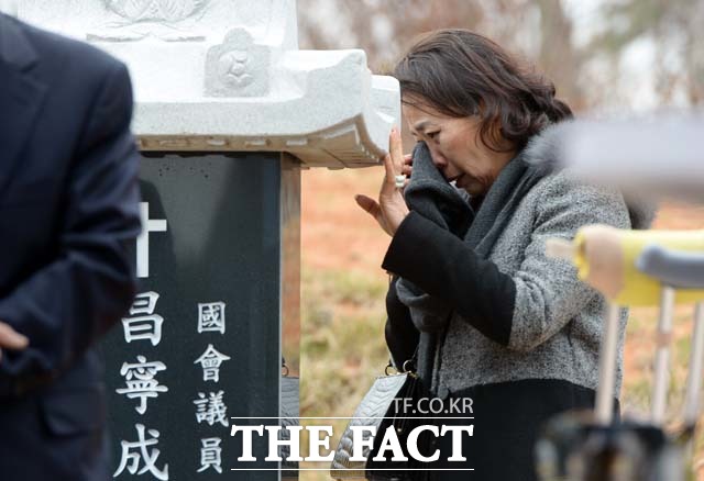 사돈 김미경씨가 묘비 옆에서 눈물을 훔치고 있다.
