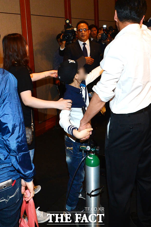 가습기 살균제 피해자인 아동이 아타 울라시드 사프달 옥시 한국법인 대표에게 항의하고 있다.