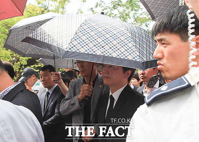 시민들의 거센 항의에 우산 경호를 받고 있는 안철수 국민의당 대표./봉하마을=문병희 기자