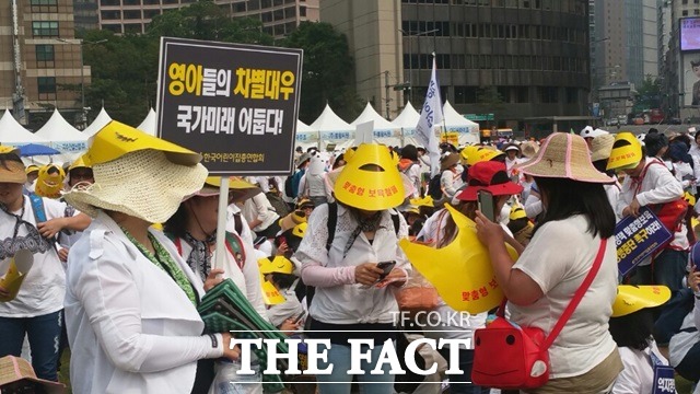 집회에 참석한 어린이집 교사들이 피켓을 들고 시위를 하고 있다.