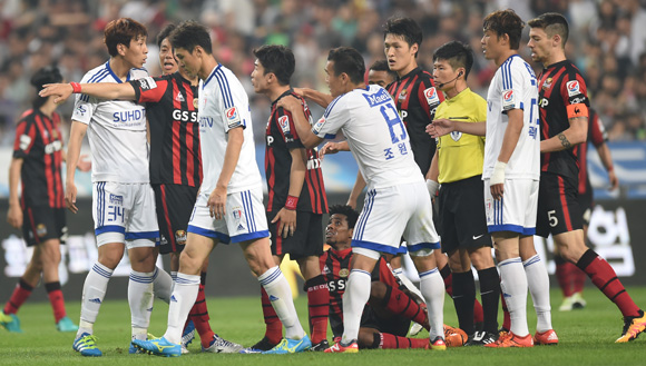경기가 과열되자 서울 아드리아노가 거친 플레이에 그라운드에 쓰러지자 양팀 선수들이 신경전을 벌이고 있다.