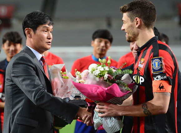 고별식을 가진 서울 최용수 감독에게 주장 오스마르가 꽃다발을 전달하고 있다.