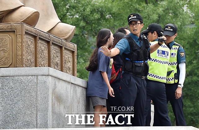 알바노조 관계자들이 최저임금 1만원을 요구하며 12일 서울 오전 광화문 광장 세종대왕 동상 위에서 기습 시위를 벌이며 경찰과 대치하고 있다. / 이새롬 기자