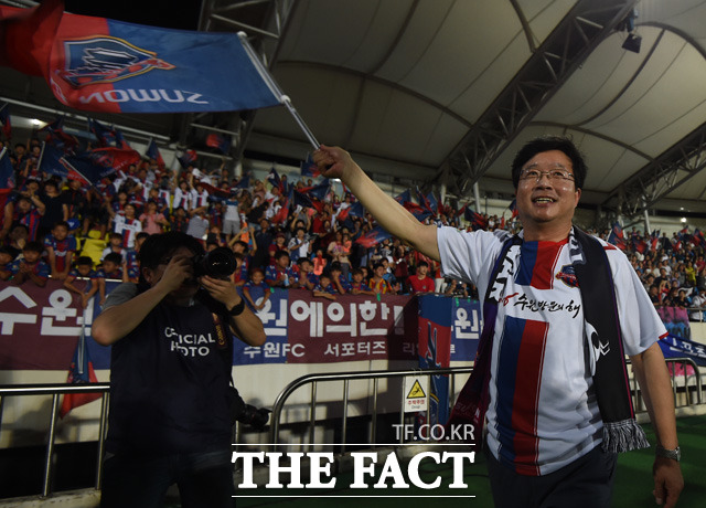 깃발전쟁에서 승리한 수원FC 염태영 시장이 서포터즈들 앞에서 승리를 자축하고 있다.