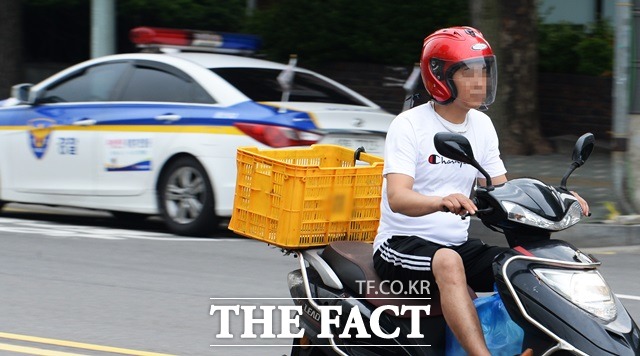 최근 패스트푸드업체들의 시간 내 배달제가 또다시 도마에 올랐다. 지난 12일 오후 서울 용산구 한강대로 서울역 주변에서 오토바이를 탄 한 시민이 헬멧에 달린 턱끈을 하지 않은 채이동하고 있다(사진은 기사 내용과 관련 없음)./이덕인 기자