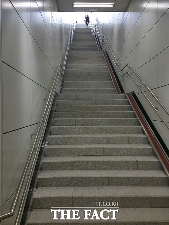 인천지하철 2호선 인천가좌역 2번 출구 93개의 계단은 한눈에 보아도 가팔라 오르기 쉽지 않다는 지적이 일고 있다. 사진은 계단을 힘겹게 오르는 여성. /인천=신진환 기자