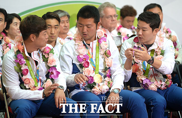 진종오 선수(오른쪽)가 부러운 눈으로 이승윤 선수(왼쪽)와 김우진 선수을 바라봅니다. 무슨 일일까요?