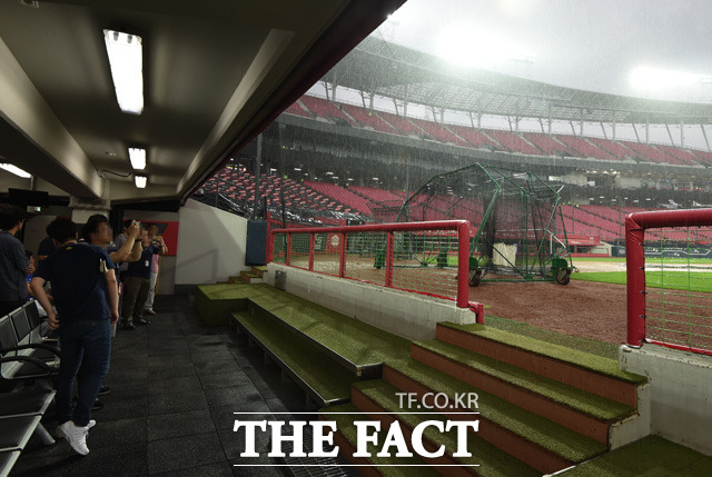 광주챔피언스필드에 폭우가 쏟아지고 있는 가운데 삼성-KIA의 경기가 우천으로 취소되자 취재진들이 더그아웃에서 비를 피하고 있다.