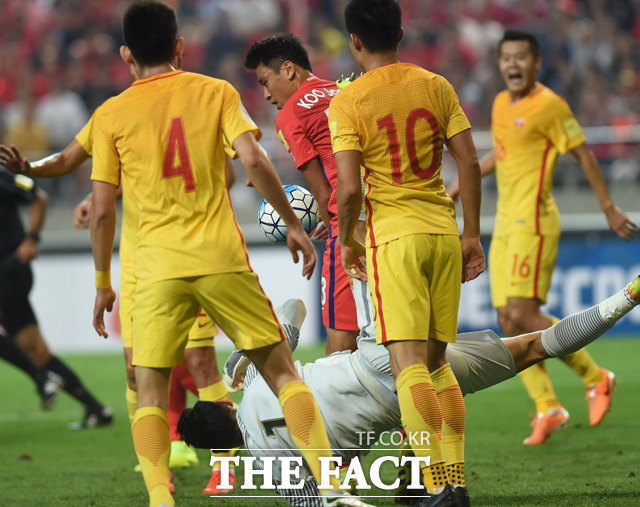 한국 구자철이 중국 문전에서 헤딩슛을 시도하기 위해 거친 몸싸움을 벌이고 있다.