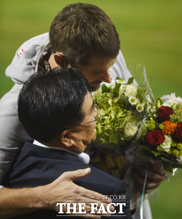 역대 최소경기(25경기), 최고령(35세 4개월 7일) 20승 기록을 세운 두산  니퍼트가 김태룡 단장에게 꽃다발을 받고 포옹을 나누고 있다.