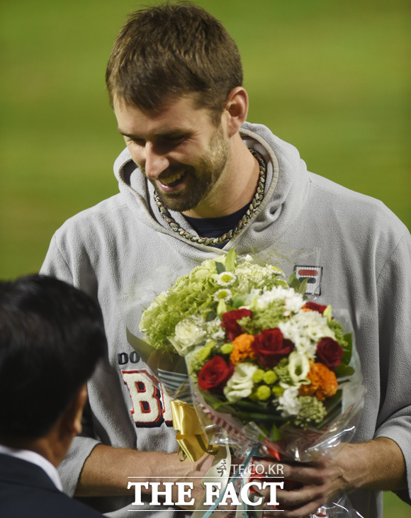 역대 최소경기(25경기), 최고령(35세 4개월 7일) 20승 기록을 세운 두산  니퍼트가  꽃다발을 받고 환하게 웃고 있다.