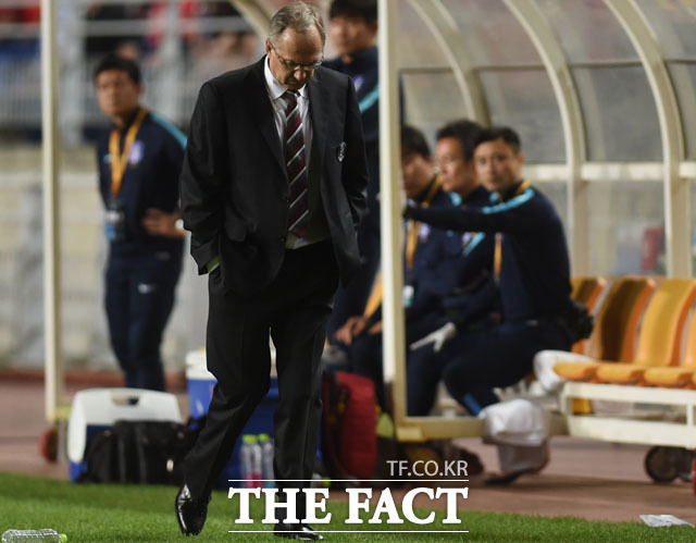 한국 슈틸리케 감독이 1-2로 리드를 당하지 고개를 숙이며 생각에 잠겨 있다.