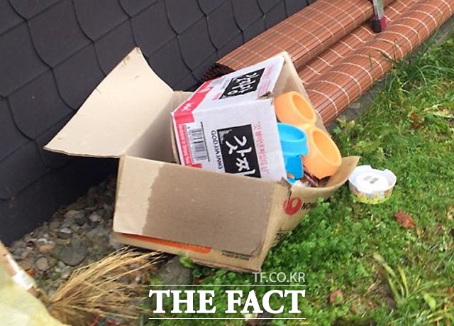 버려진 라면박스와 개밥그릇 주택 마당에 라면과 짜장면 박스, 개밥그룻이 놓여져 있다.