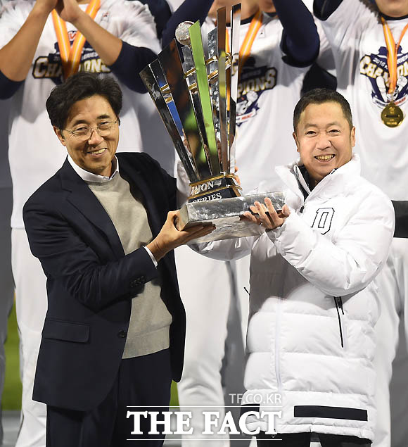 두산 박정원 회장과 김승영 사장이 우승 트로피를 들어보이고 있다.