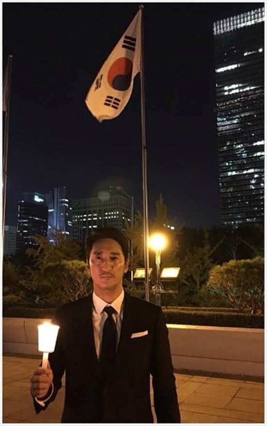 신현준이 태극기 앞에서 촛불을 들고 서 있다. /신현준 인스타그램