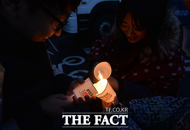 박근혜 대통령의 퇴진을 요구하는 5차 촛불집회가 26일 오후 서울 종로구 광화문 일대에서 열린 가운데 시민들이 경복궁역 인근에서 촛불을 나누고 있다./문병희 기자