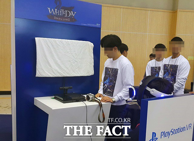 한 관람객이 지스타 2016에 출품된 ‘화이트데이:스완송’을 즐기고 있다. 흰색 천으로 덮인 모니터가 인상적이다.