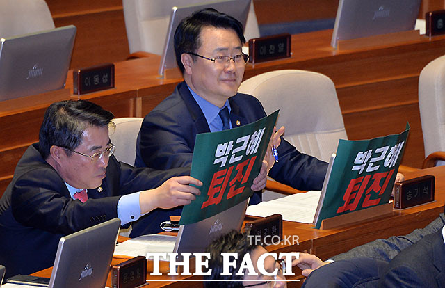 국민의당 최경환(왼쪽)과 송기석 의원이 박근혜 탄핵이 적힌 피켓을 모니터 앞에 걸고 회의에 참석하고 있다.