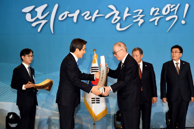박준 농심 대표이사(오른쪽)가 황교안 국무총리로부터 1억불 수출의 탑 트로피를 전달받고 있다. /농심 제공