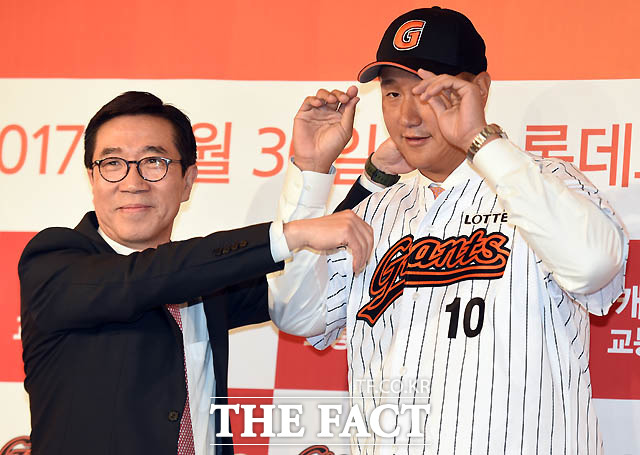 롯데자이언츠 김창락 대표이사가  입단한 이대호에게 유니폼과 모자를 씌워주고 있다.