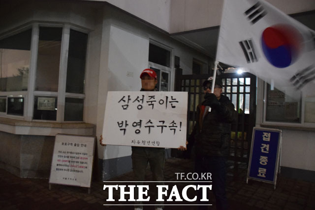 이재용 삼성전자 부회장의 구속영장 기각을 주장하는 단체 회원들이 서울구치소 앞에서 삼성 죽이는 박영수 구속이라는 팻말을 들고 서있다.