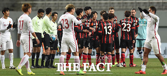 0-1로 패한 서울 선수들이 아쉬워하는 사이 결승골을 넣은 상하이 헐크가 동료들과 하이파이브를 나누며 기뻐하고 있다.