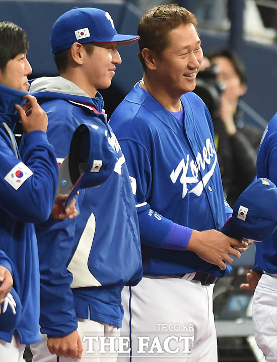 한국대표팀 이대호가 애국가 연주 후 부동자세를 취하는 이대은(경찰청)을 보며 웃고 있다.