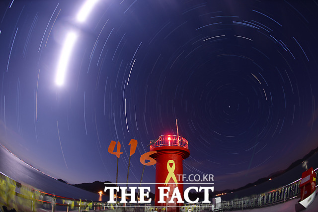 리멤버 4.16 2014년 12월 겨울, 시리도록 파란 밤하늘 아래 작은 별빛들이 팽목항 하늘을 맴돌고 있다. 시간이 지나도 변함없는 별처럼 세월호 참사는 우리의 기억 속에 영원히 맴돌 것이다. 조리개 5.6으로 20초간 개방해 3시간 동안 촬영한 250여장의 사진을 한 장으로 합성했다.