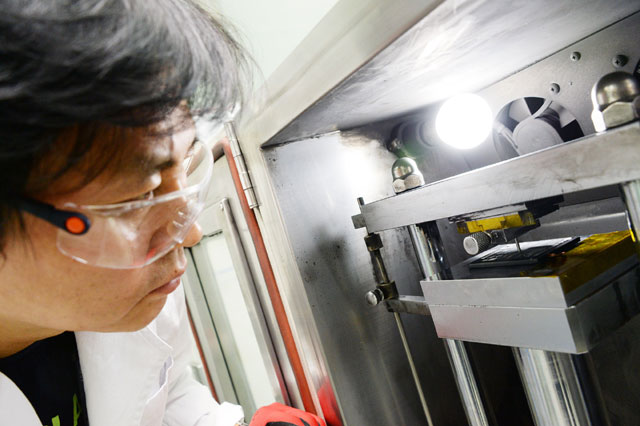 LG전자 연구원이 G6 배터리를 놓고 관통 시험을 진행하고 있다.