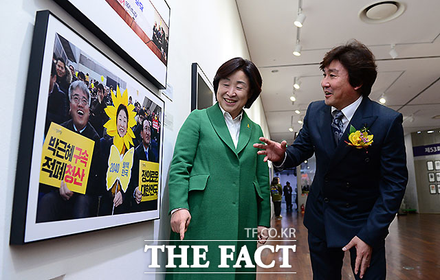 정의당 심상정 대표(왼쪽)가 본인이 찍힌 사진에 대해 한국사진기자협회 이동희 회장의 설명을 듣고 있다.