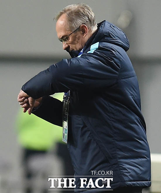 한국 슈틸리케 감독이 경기 종반 시리아에 밀리자 시계를 바라보고 있다.