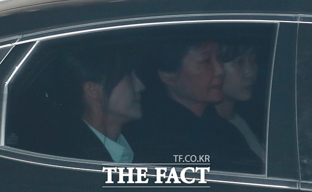 박 전 대통령은 승용차를 타고 300m 거리의 검찰청 임시 유치장소로 이동했는데, 특히 뒷자리에 여성 수사관 사이에 끼어 앉은 모습이 눈길을 끌었다. /사진공동취재단
