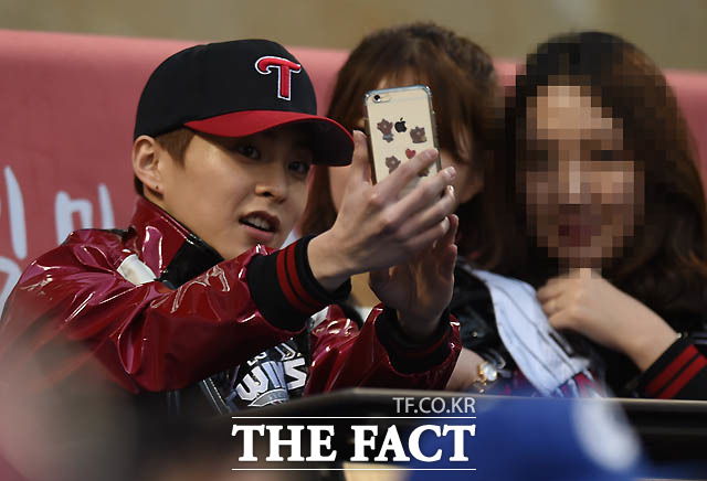 아이돌 그룹 EXO 시우민이 시구 후 관중석에서 경기를 지켜보다 팬들과 사진을 찍고 있다.