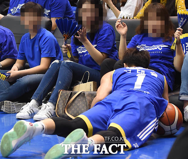 삼성 김태술이 거친 몸싸움을 펼치다 관중석을 덮치고 있다.