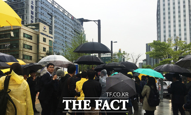 심상정 후보를 쫓는 취재진과 시민들은 내리는 비에 우산을 쓰고 이동했다. /윤소희 기자