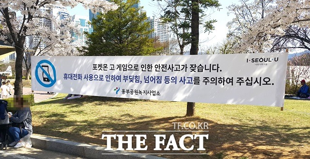 서울 동작구 보라매공원에 포켓몬고 게임을 즐길 때 이용자 안전을 당부하는 현수막이 걸려 있다. /더팩트 DB