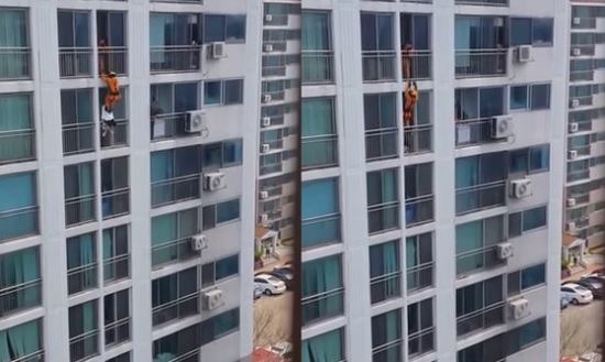소방 대원이 고층 아파트 창문 난간에 위태롭게 걸터앉은 여성을 로프에 의지한 채 날아 발차기로 창문 안으로 밀어 넣고 있다. /유튜브 영상 캡처