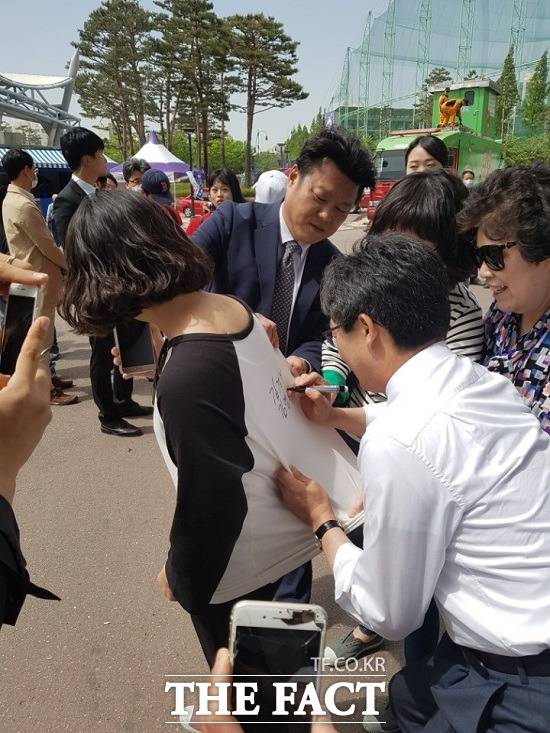 유승민 바른정당 대선후보가 40대 여성 유권자는 옷에 사인을 해주고 있다. /수원월드컵경지장=변동진 기자