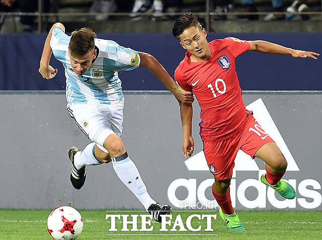 한국 이승우가 빠른 드리블을 시도하자 아르헨티나 수비수가 팔을 잡아채고 있다.