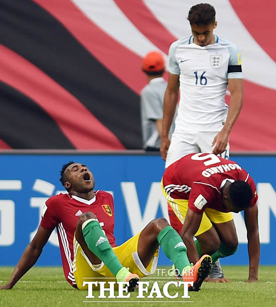 잉글랜드와 기니가 1-1로 비긴 가운데 경기 종료 후 기니 선수들이 탈진해 그라운드에 주저앉고 있다.